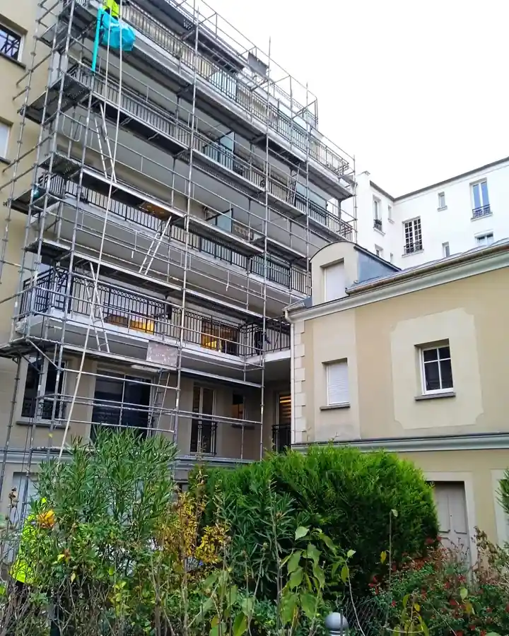 Échafaudage monté sur la façade et les balcons d'une copropriété à Paris 3e pour la reprise d'étanchéité, vue depuis la cour intérieure