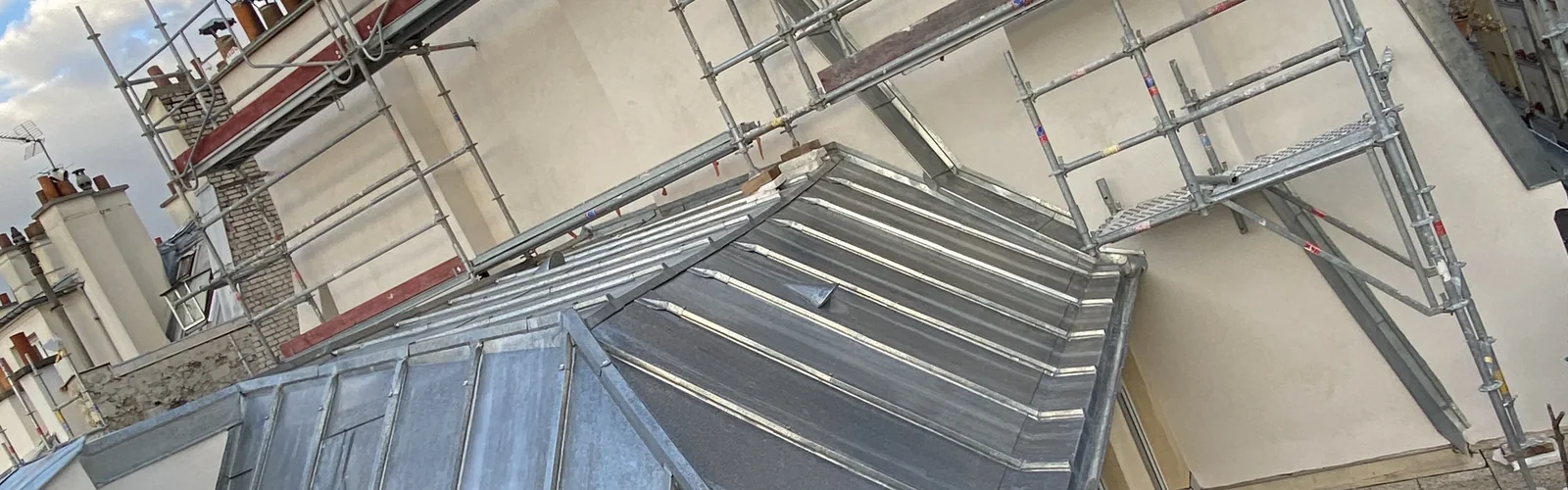 Couverture zinc à joint debout sur les toits de Paris, échafaudage monté le long du pignon