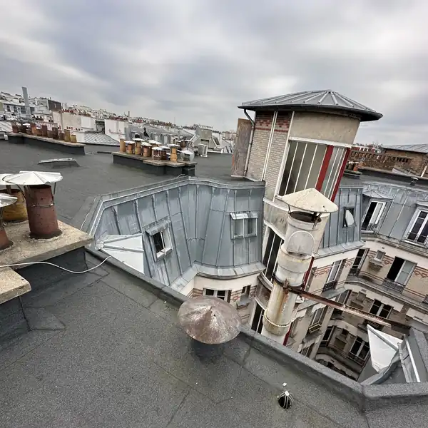 Toit terrasse d'un immeuble haussmannien à Paris, étanchéité bitumineuse entre les toits en zinc et les souches de cheminée