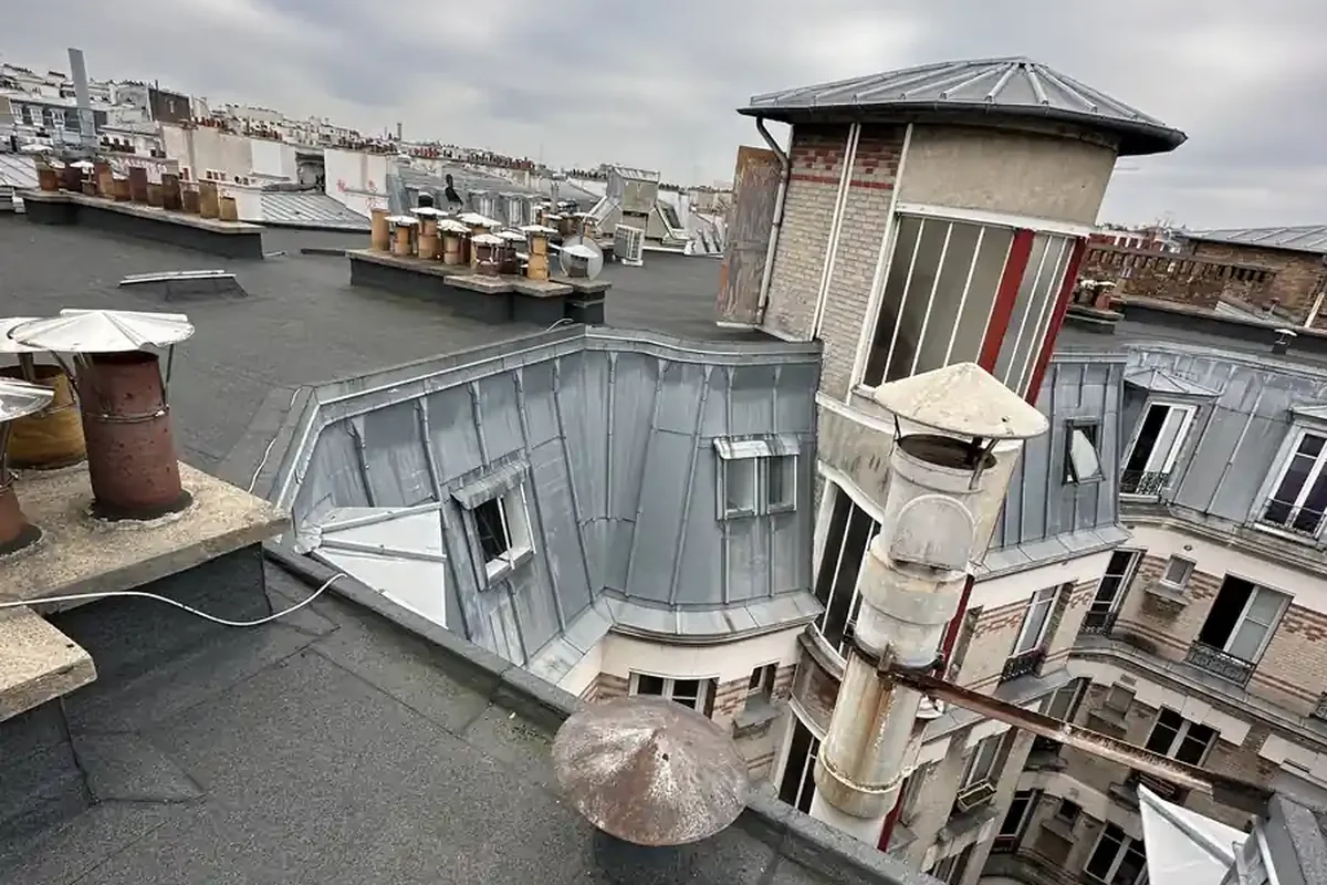 Toit terrasse parisien, souches de cheminée et couverture zinc, vue sur une cour d'immeuble